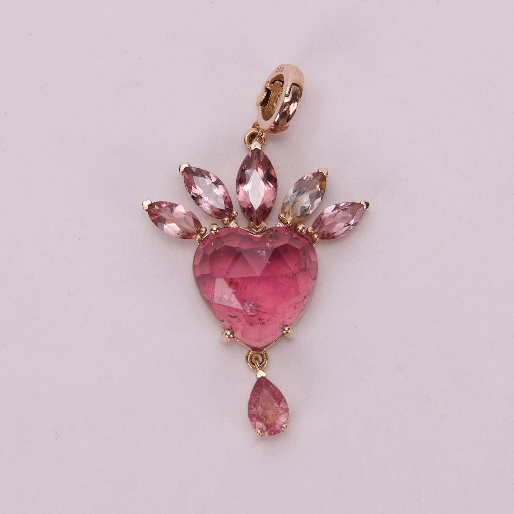Pink heart gemstone pendant with teardrop accents.