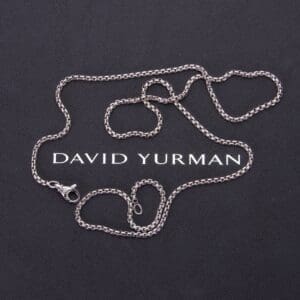 Silver chain on David Yurman branded background.