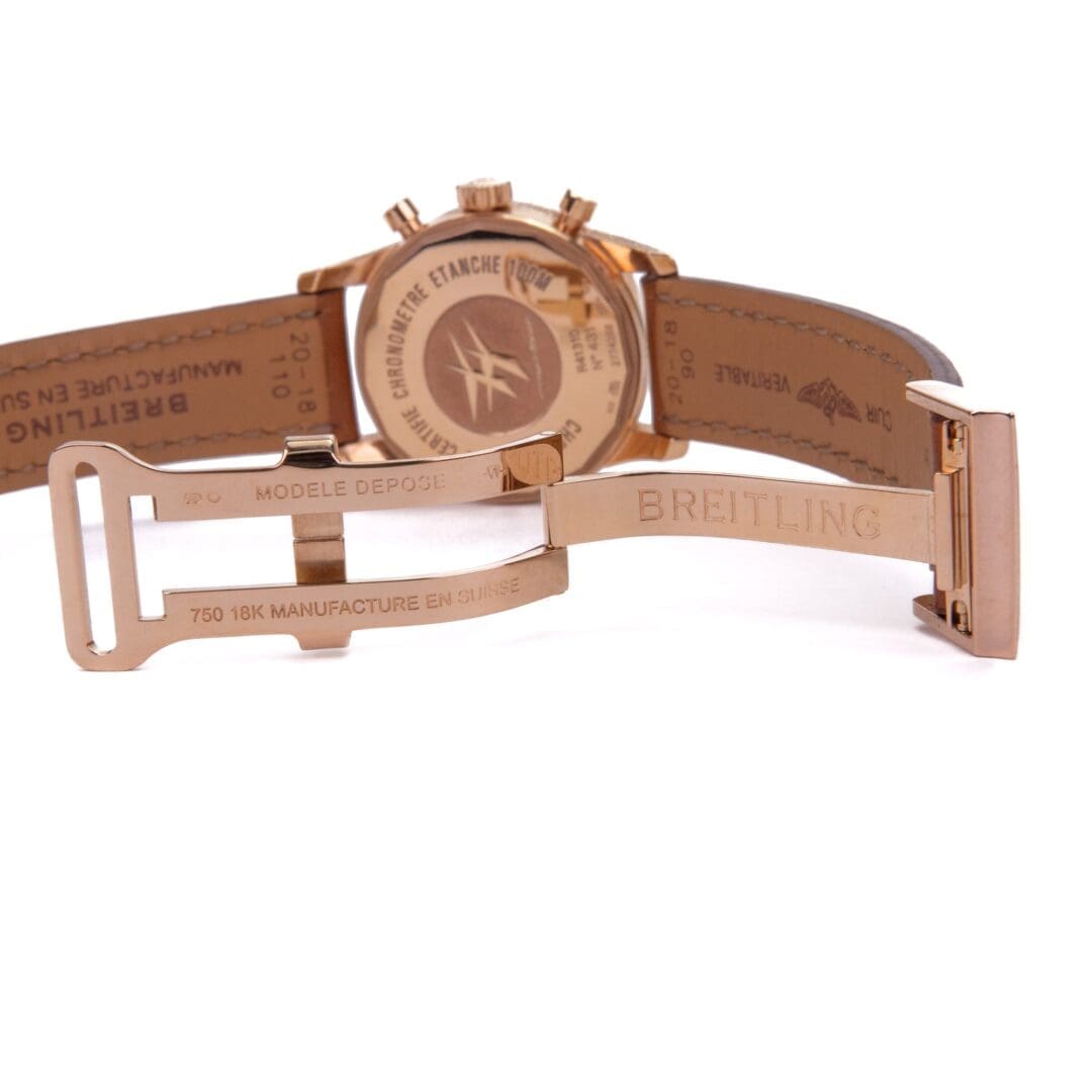 Rose gold Breitling watch with leather strap.