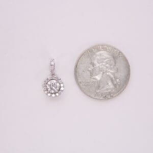 Diamond pendant next to a quarter coin.