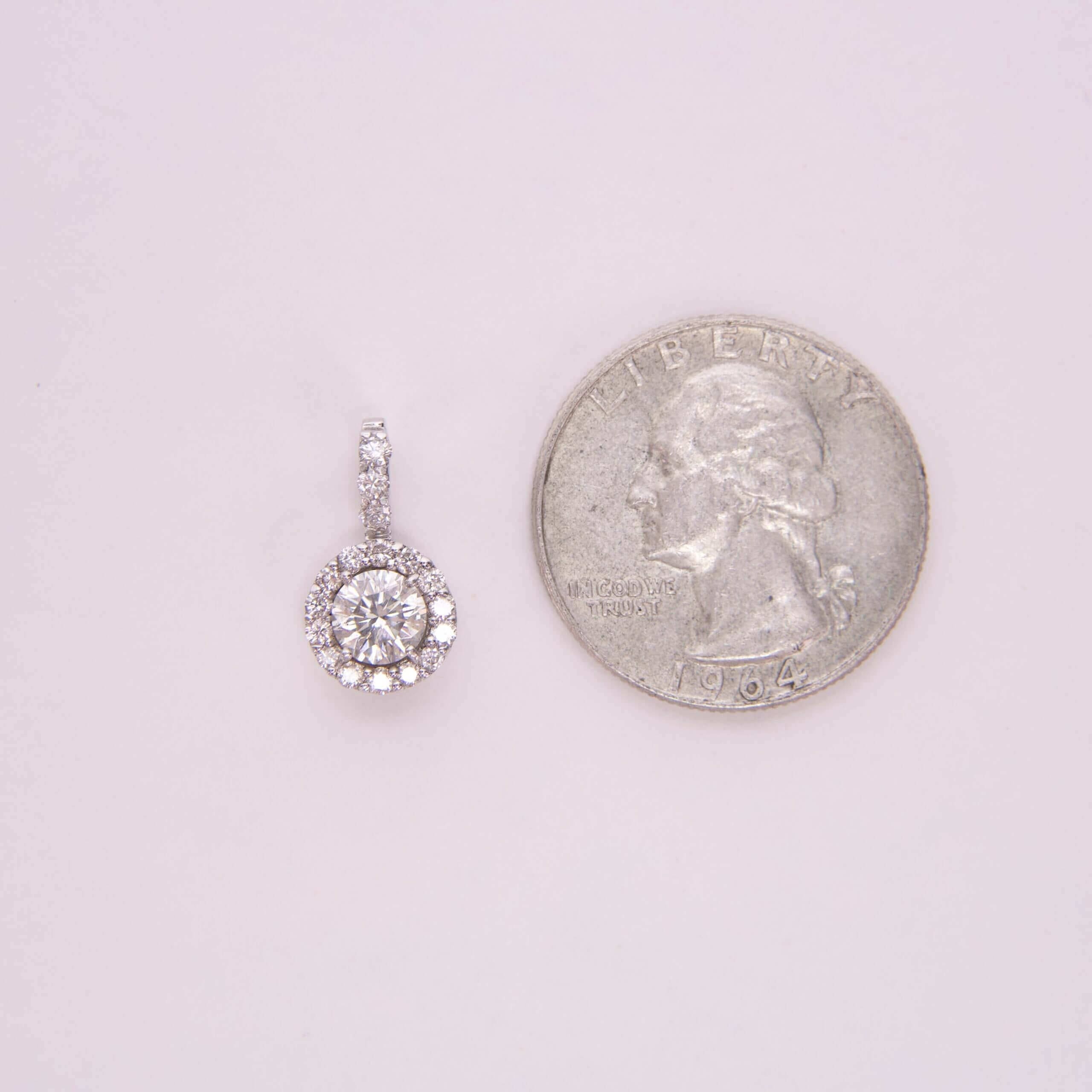 Diamond pendant next to a quarter coin.