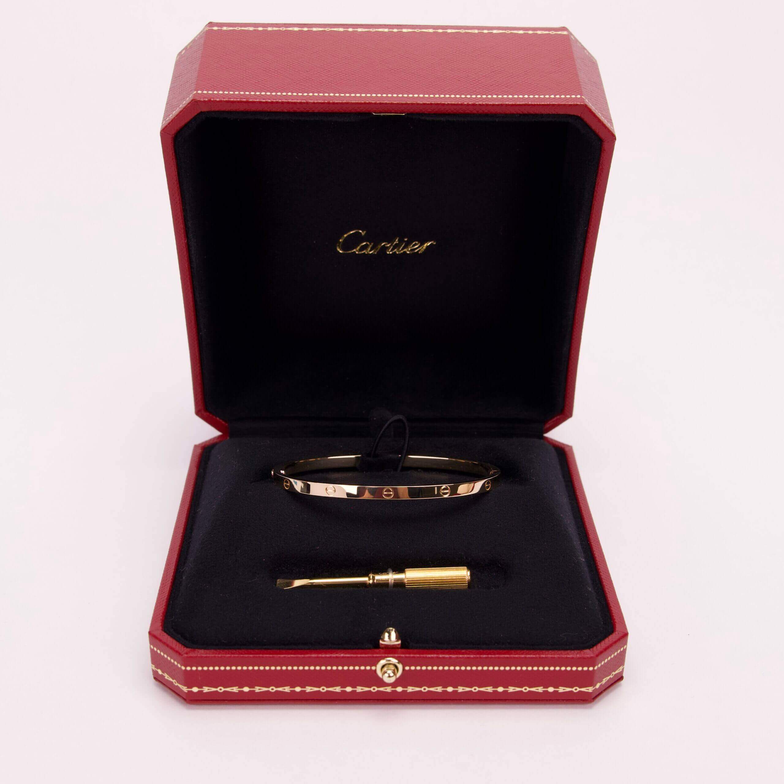 Red box with bracelet and tool inside.