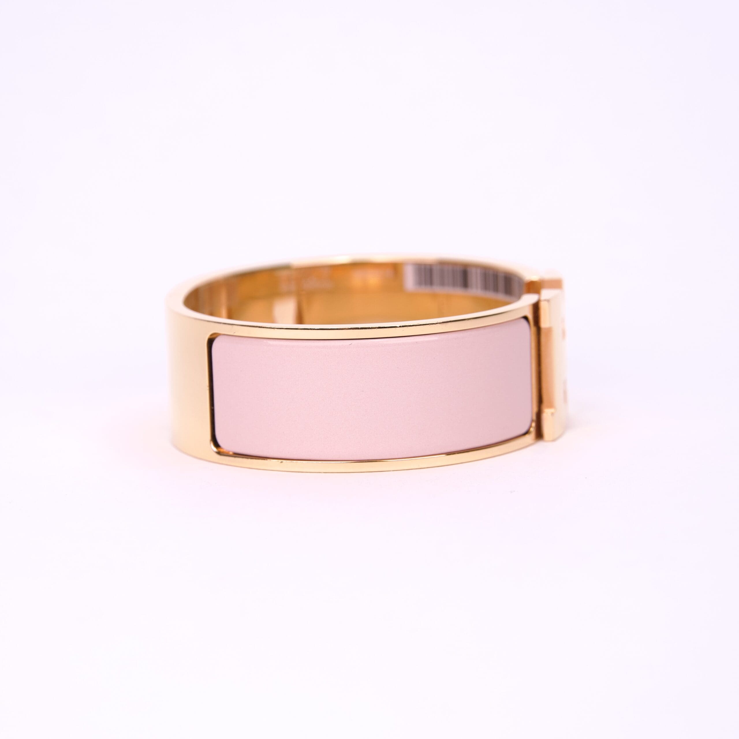 Gold bracelet with pink enamel detail.