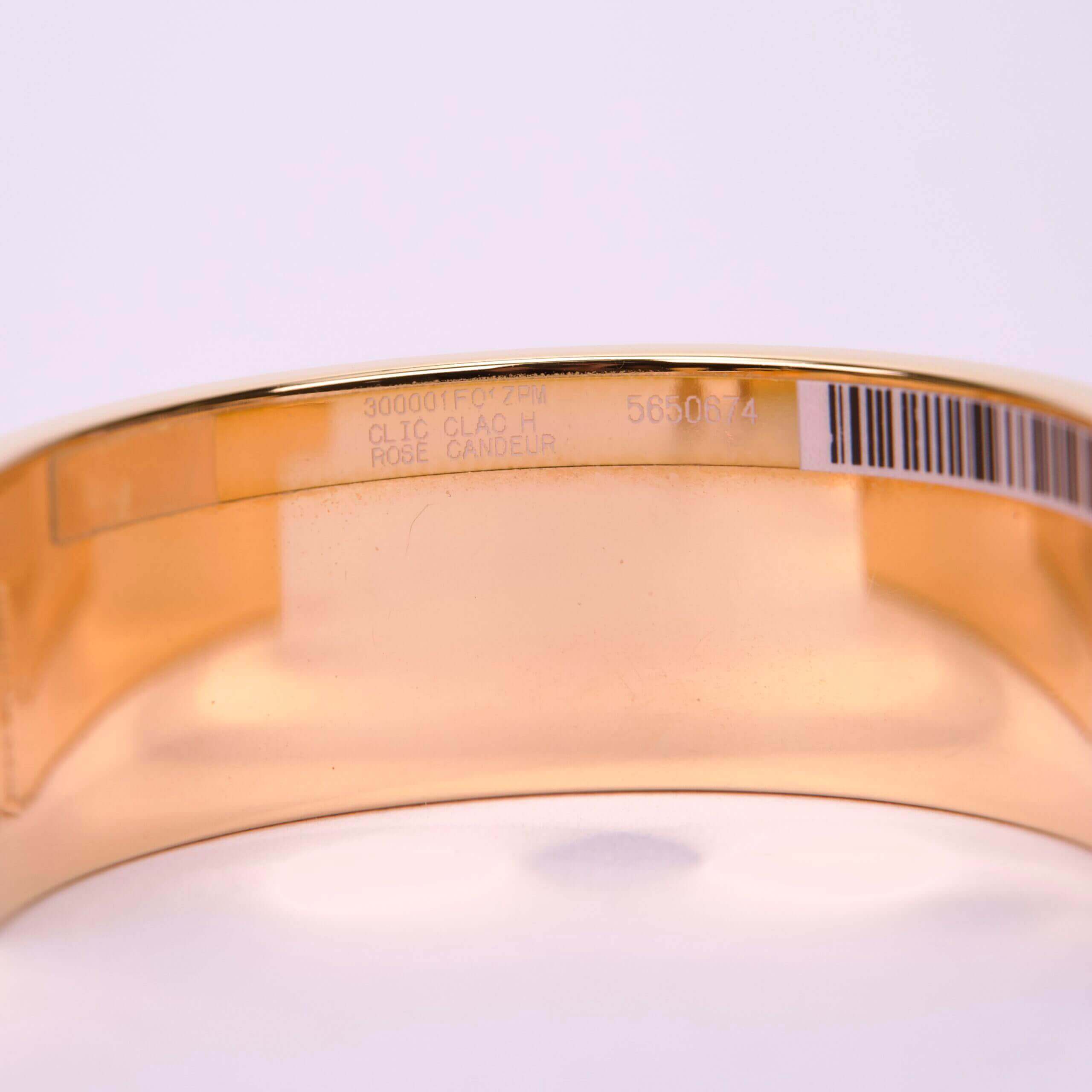 Gold bracelet with engraved text and barcode.
