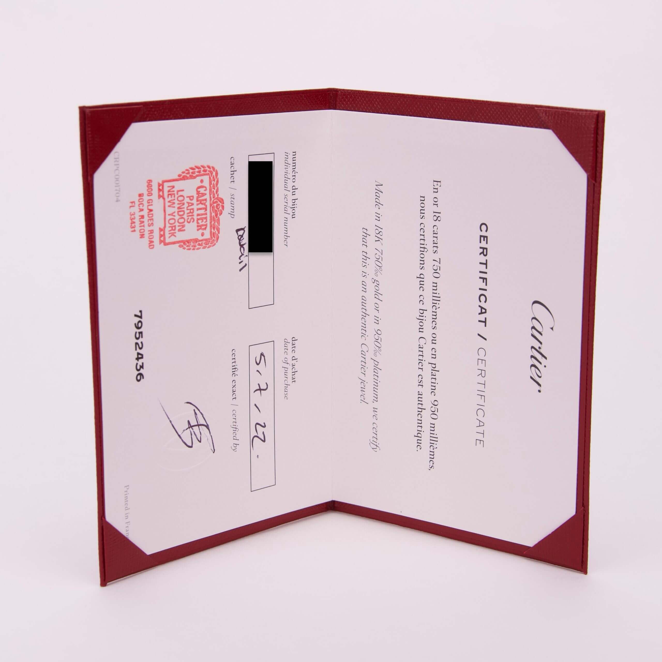 Cartier certificate in red holder, open.