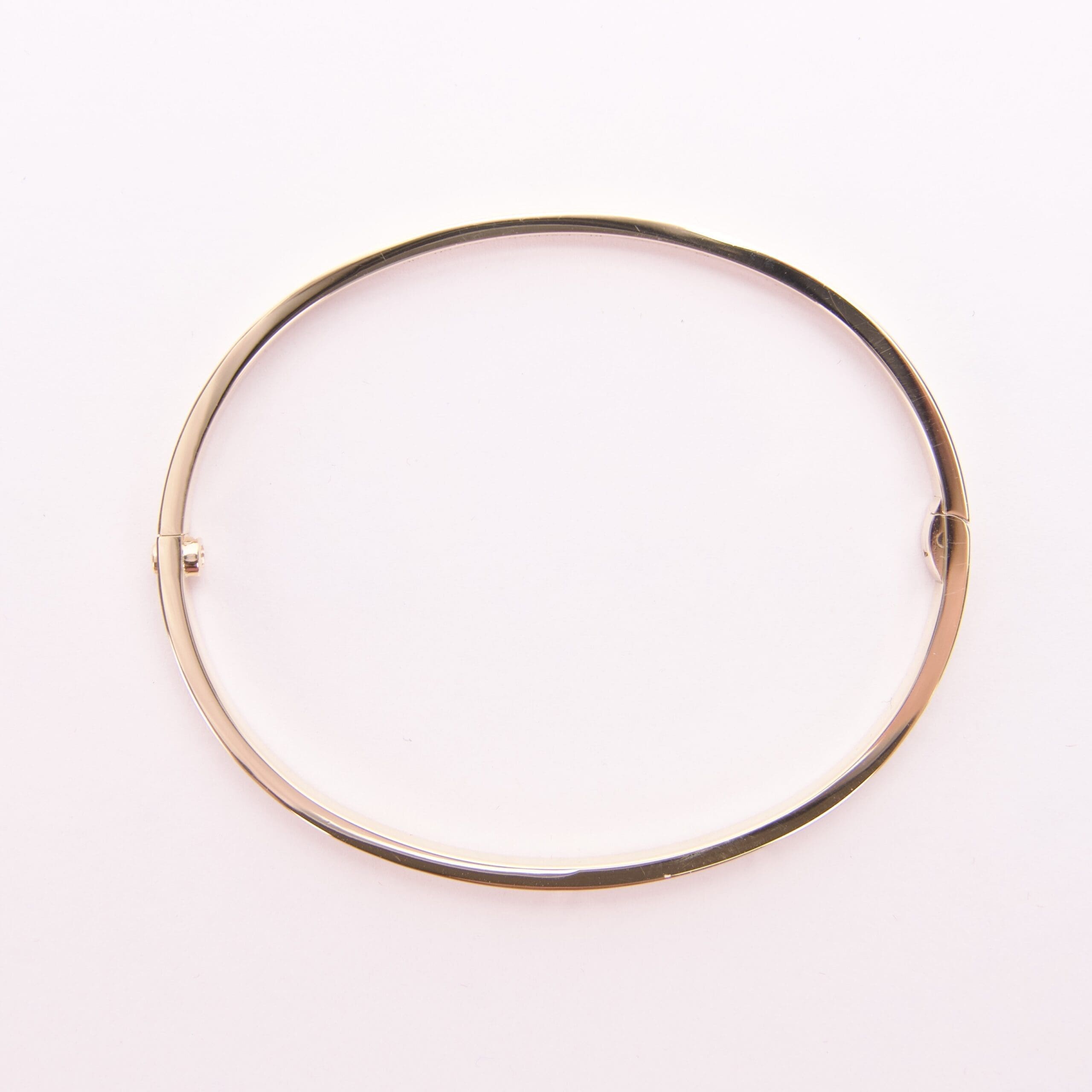 Gold bangle bracelet on white background.