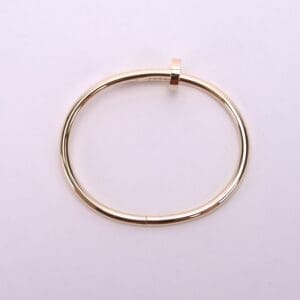 Gold bracelet on a light background.