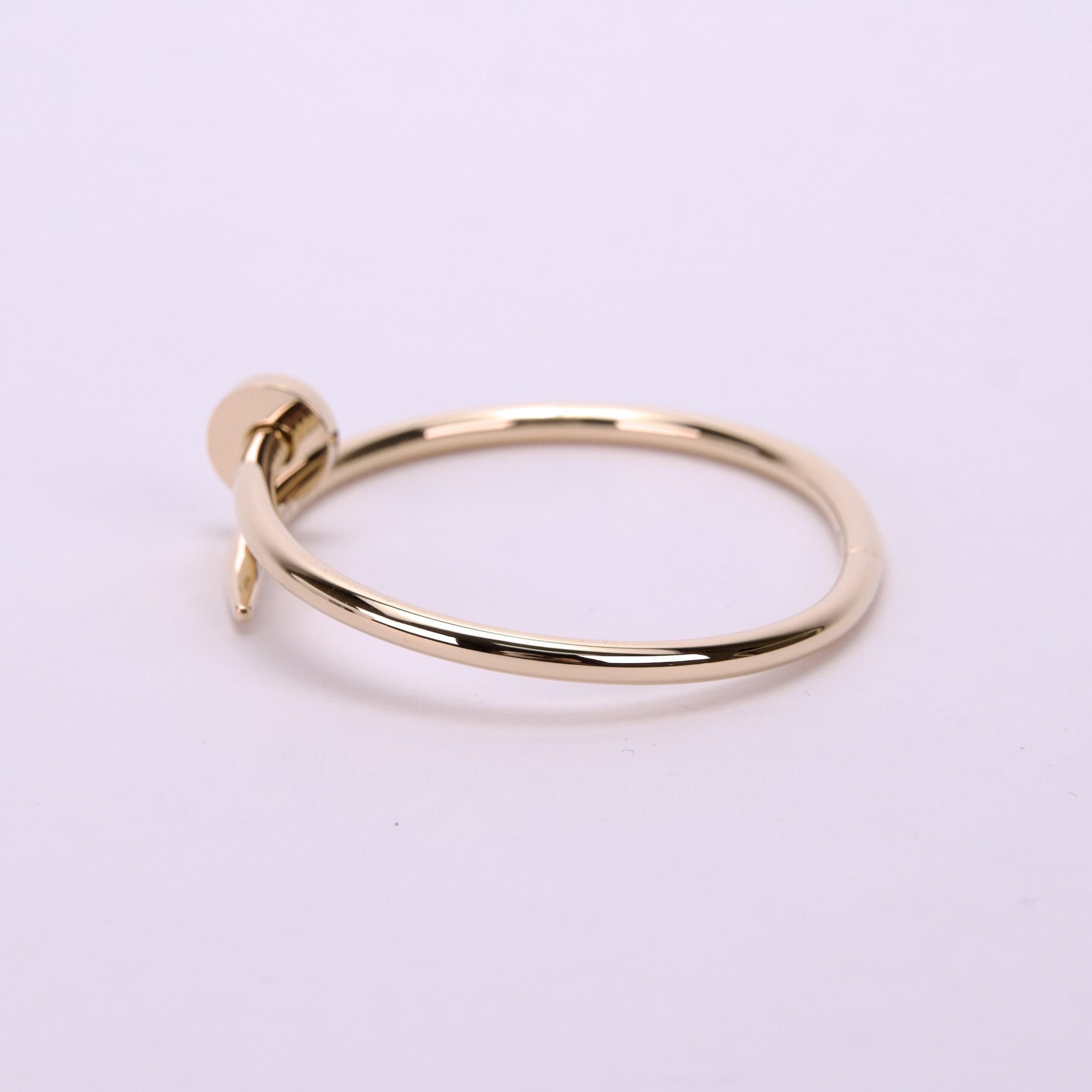 Gold bracelet with a nail design.