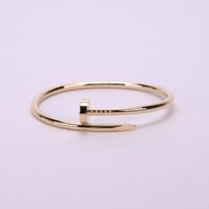 Gold nail-shaped bracelet on display.