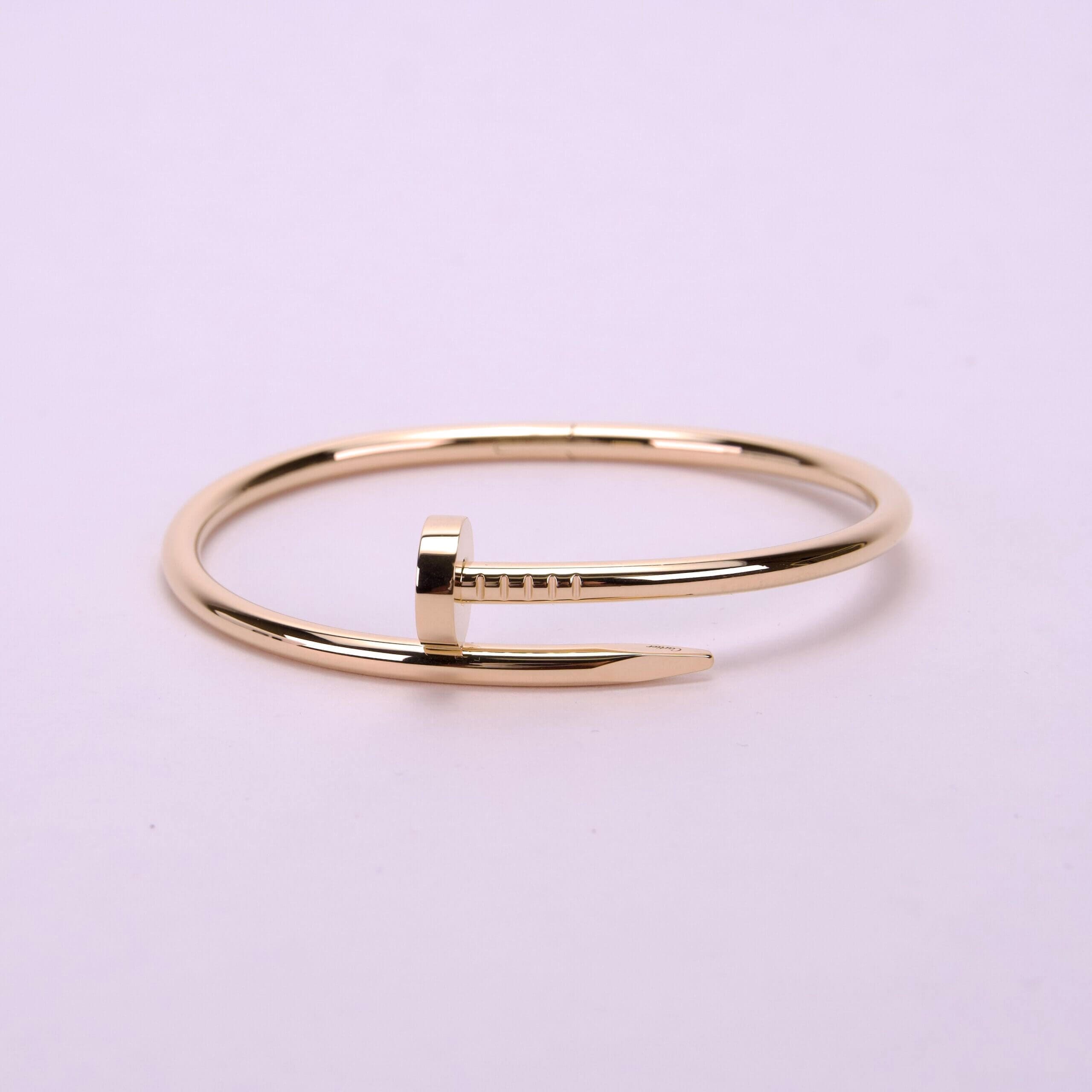 Gold nail-shaped bracelet on display.