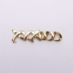 Gold-plated "XOXO" brooch on white background.