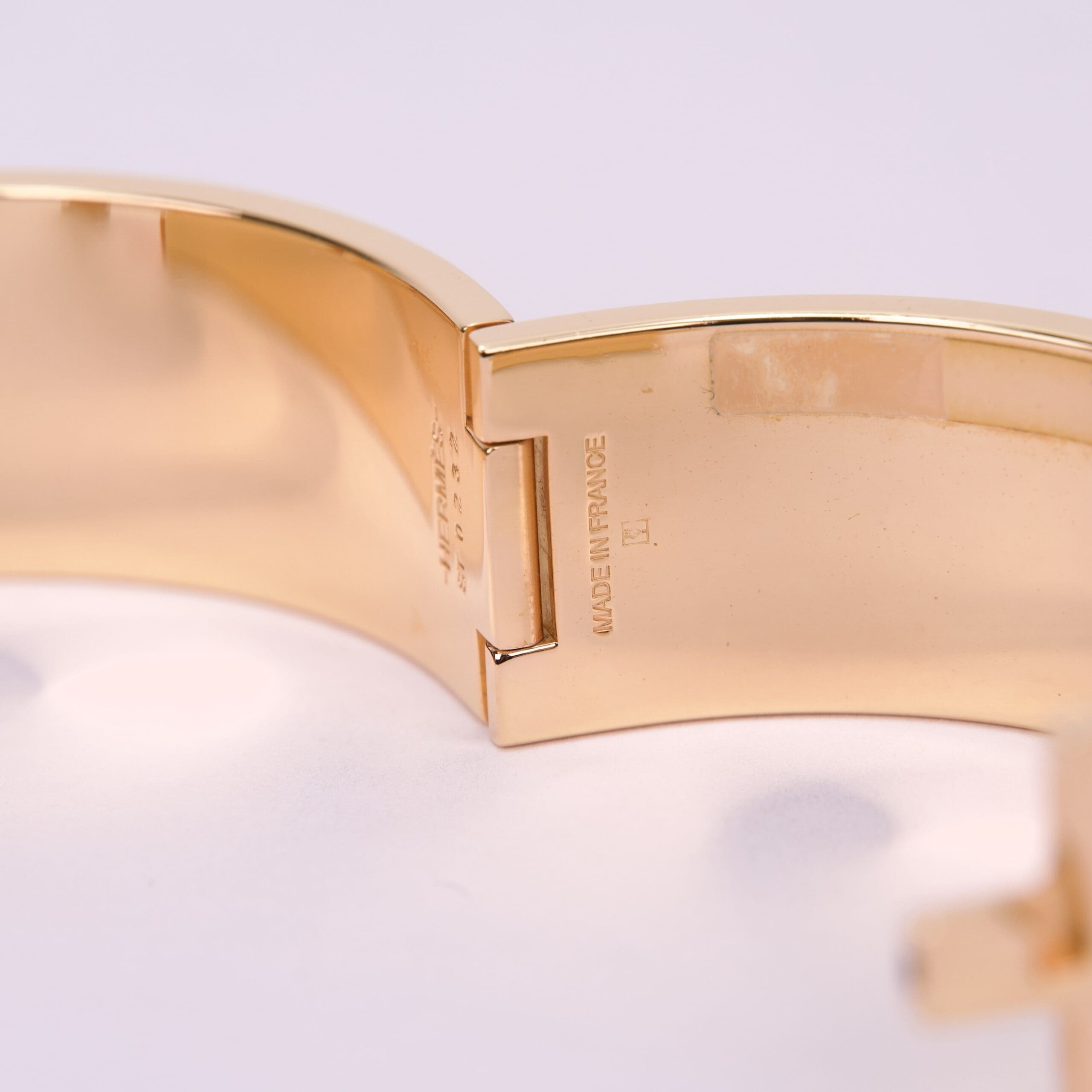 Gold bracelet with engraved text detail.