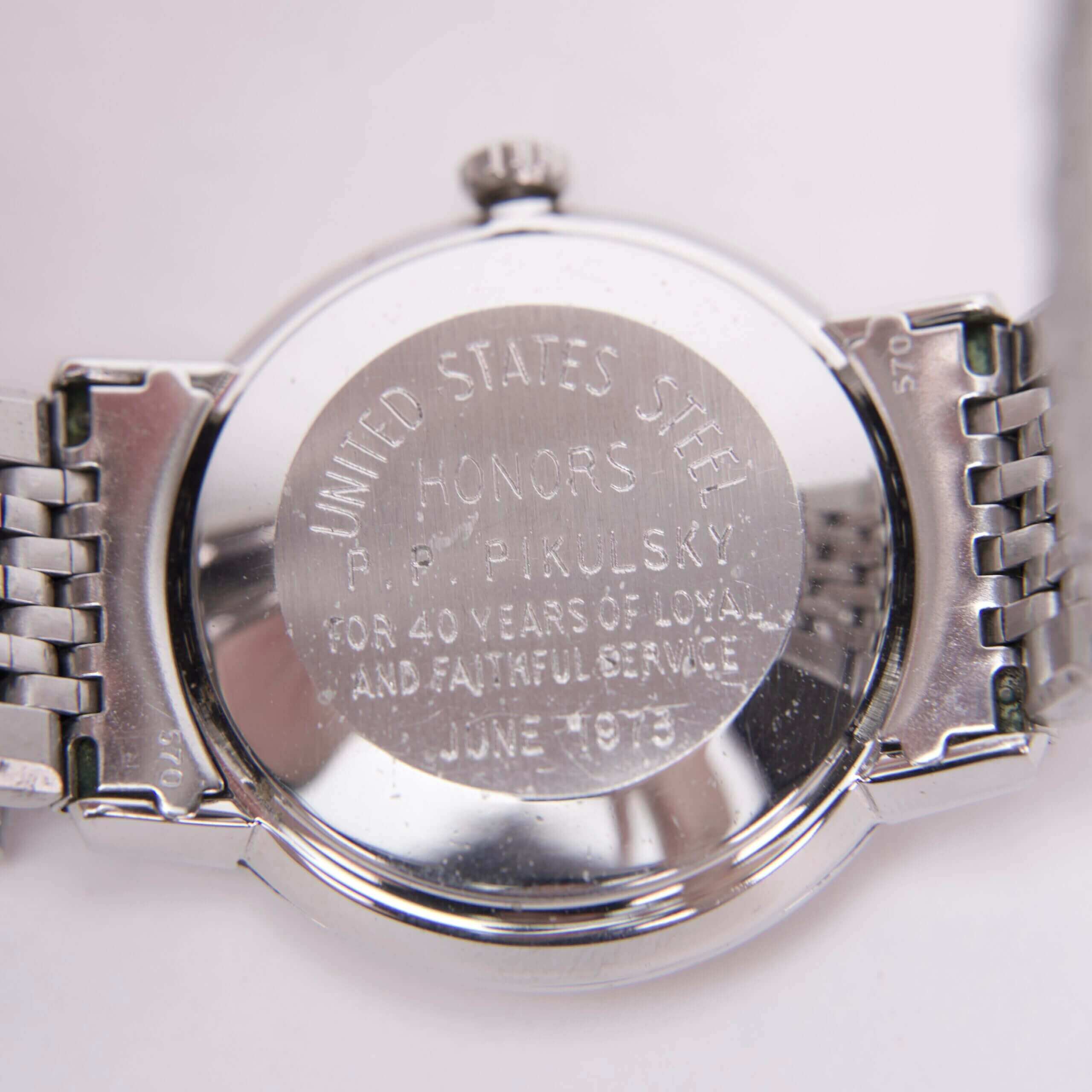 Engraved watch back with commemorative text.