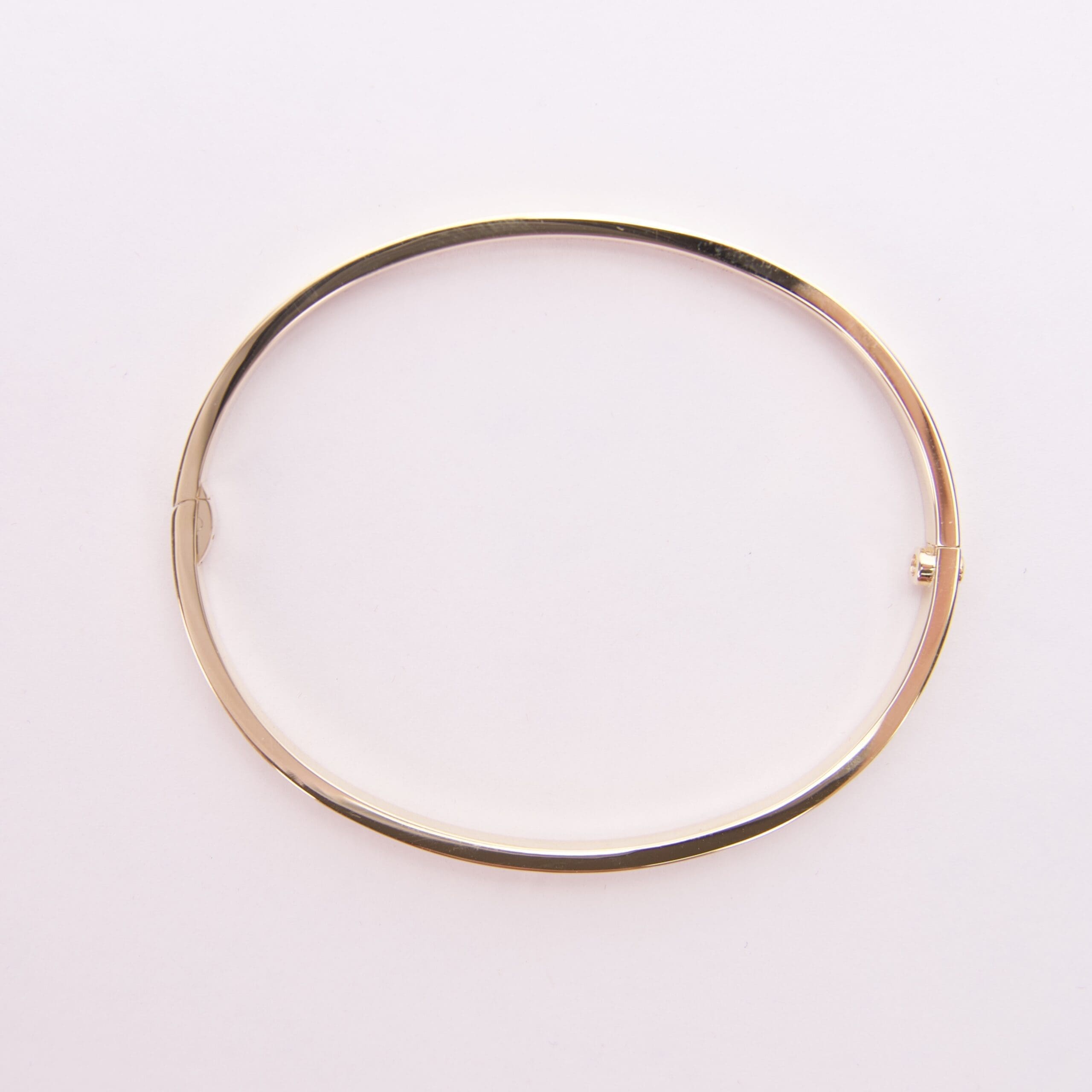 Gold bangle bracelet on white background.