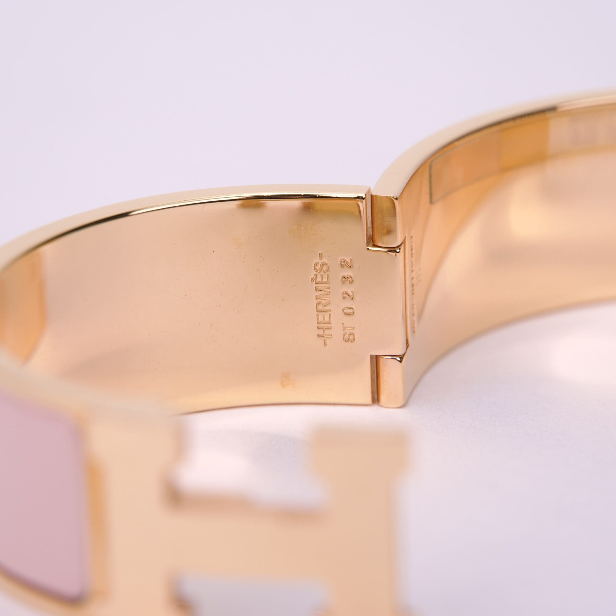 Gold bracelet with engraved brand name.
