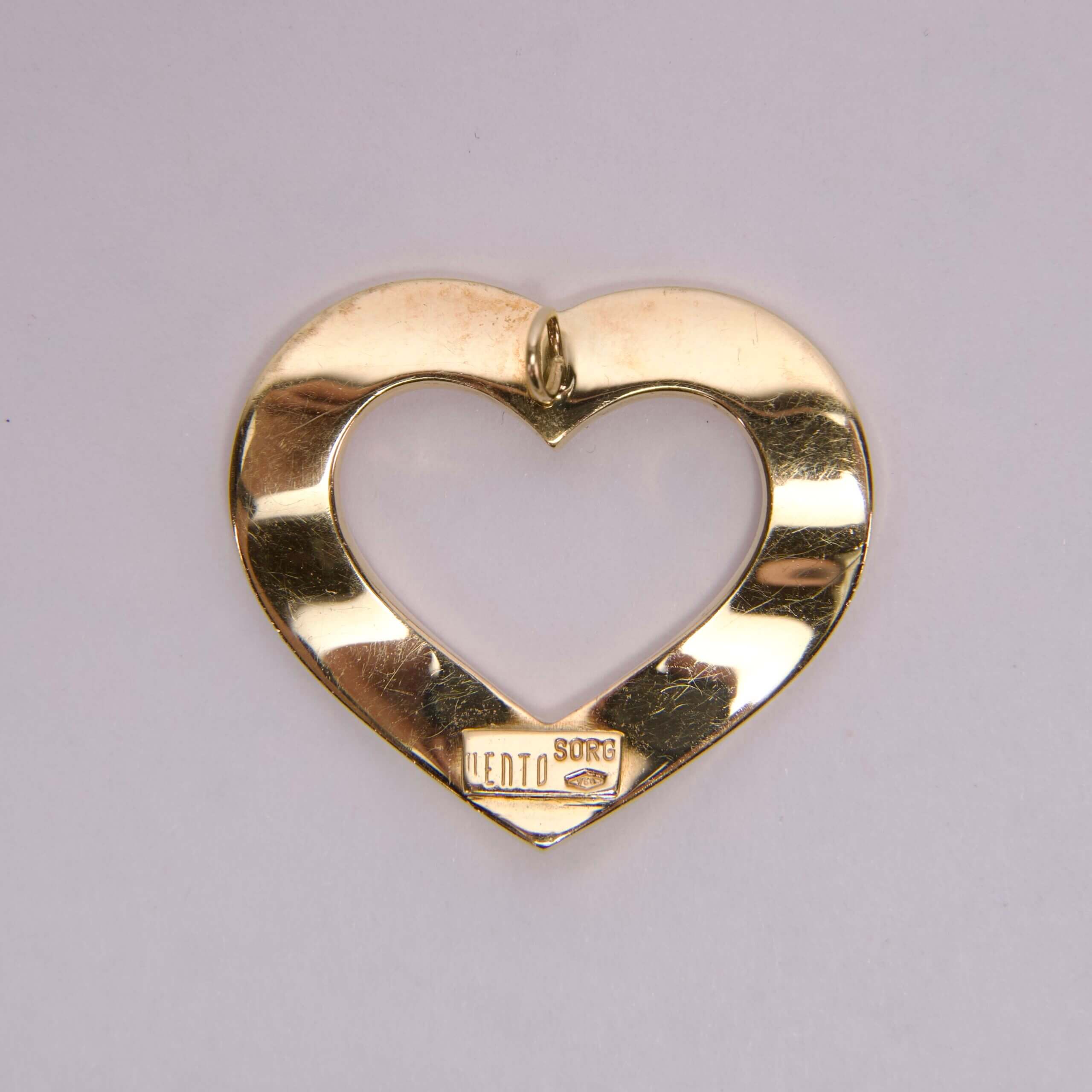 Gold heart-shaped metal object on display.