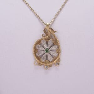 Gold necklace with floral pendant design.