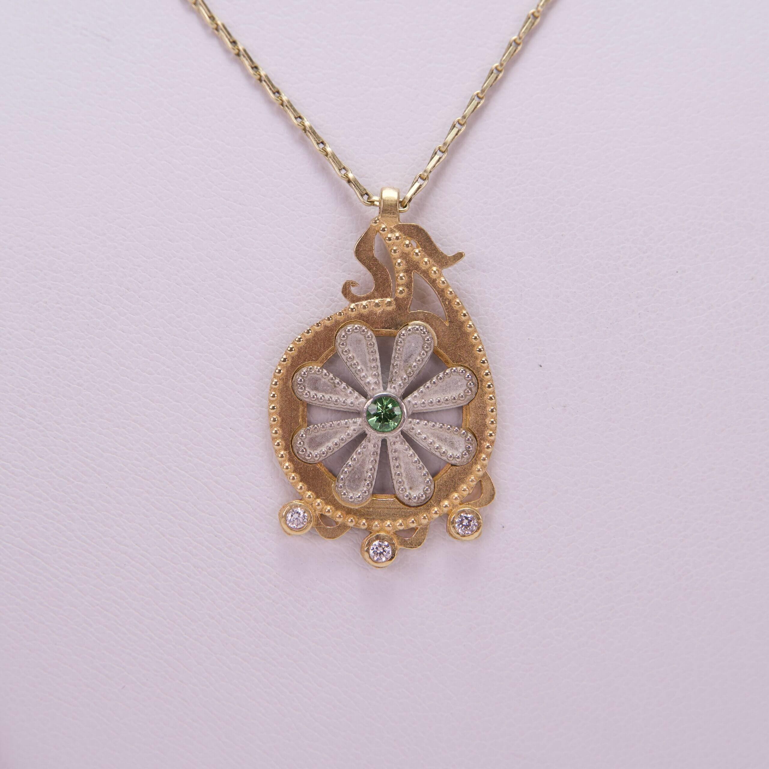 Gold necklace with floral pendant design.
