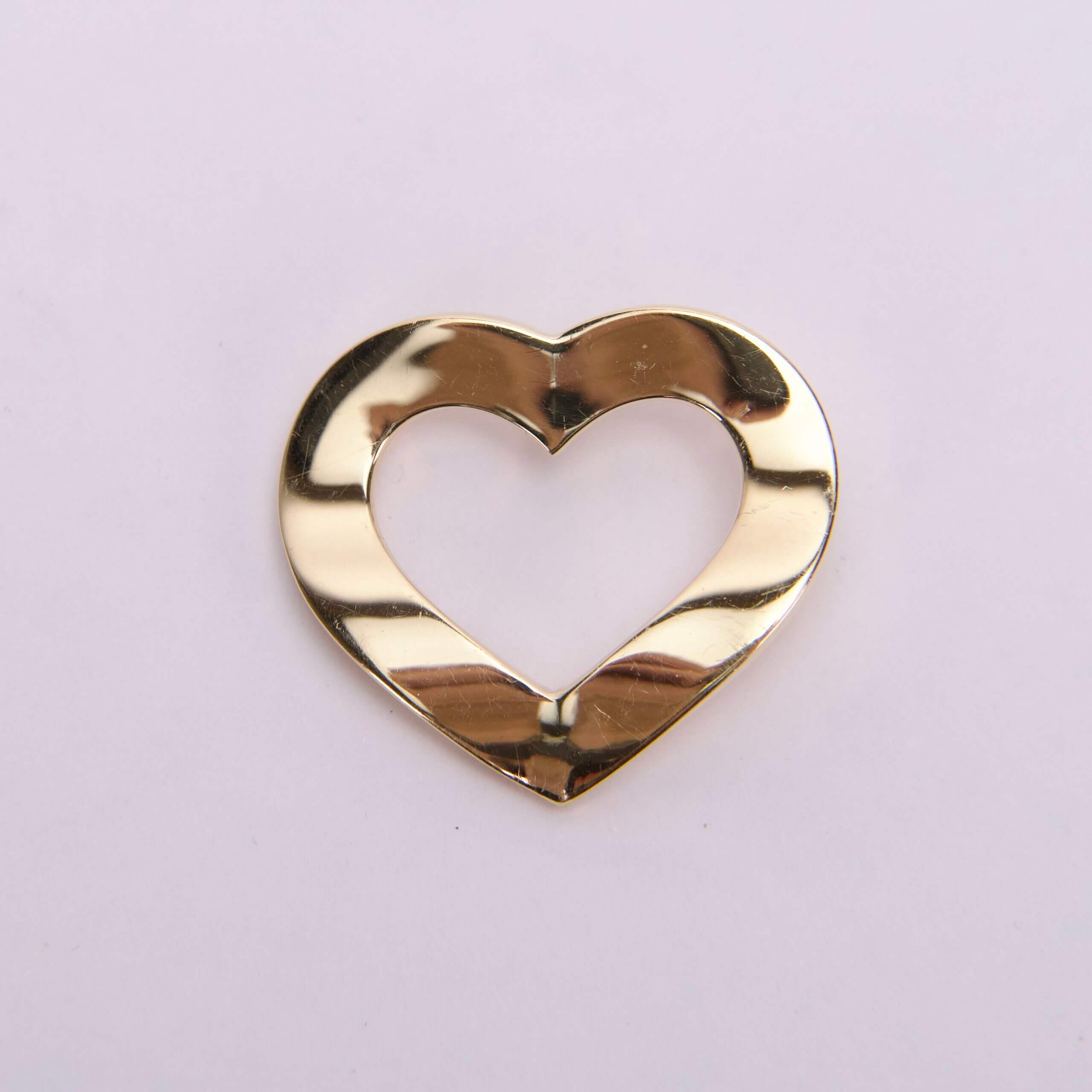 Gold heart-shaped metallic cutout on white.