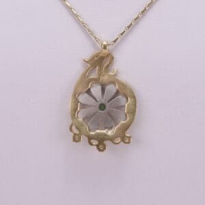 Gold necklace with floral pendant design.