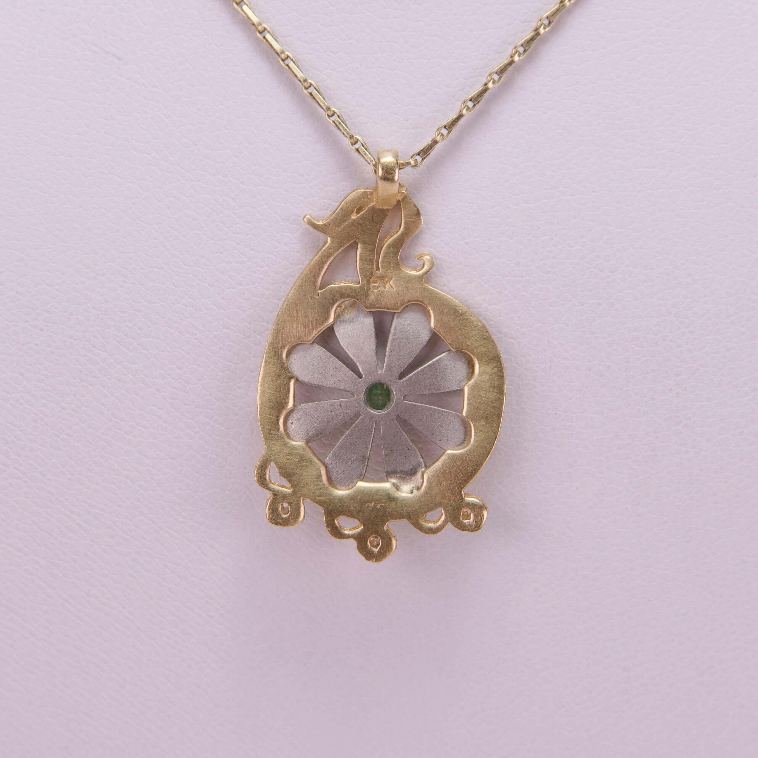 Gold necklace with floral pendant design.