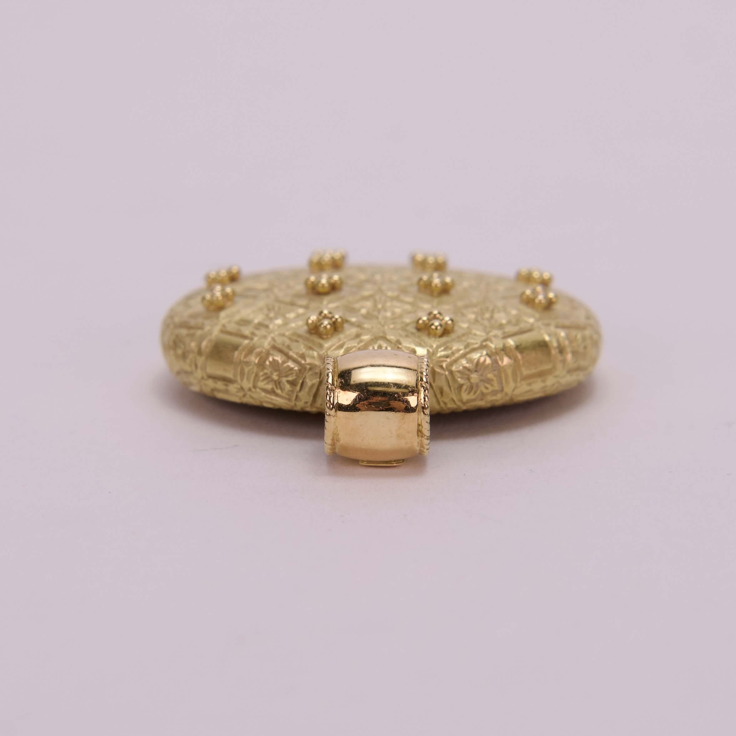Gold decorative object with intricate patterns.