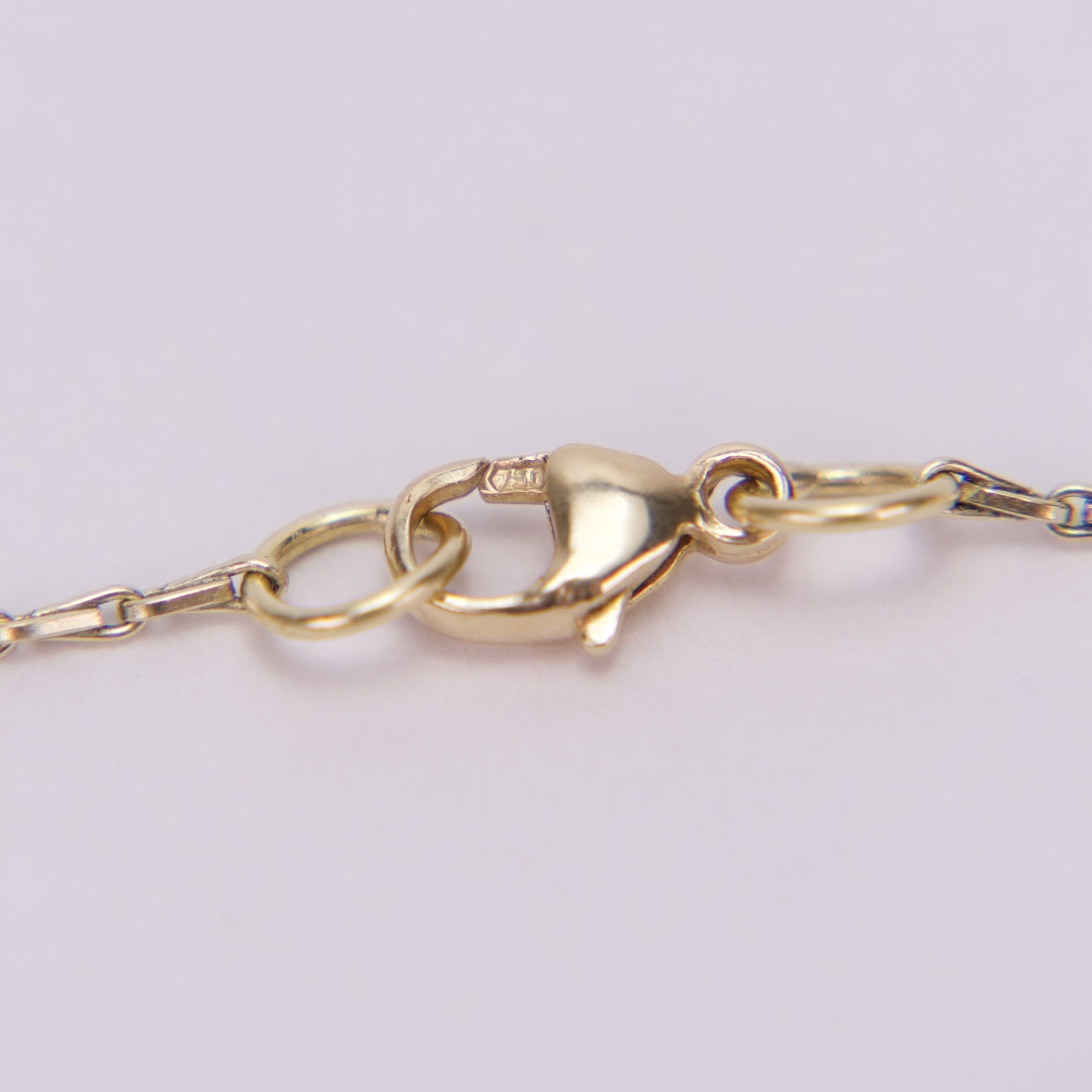 Gold lobster clasp on delicate chain.