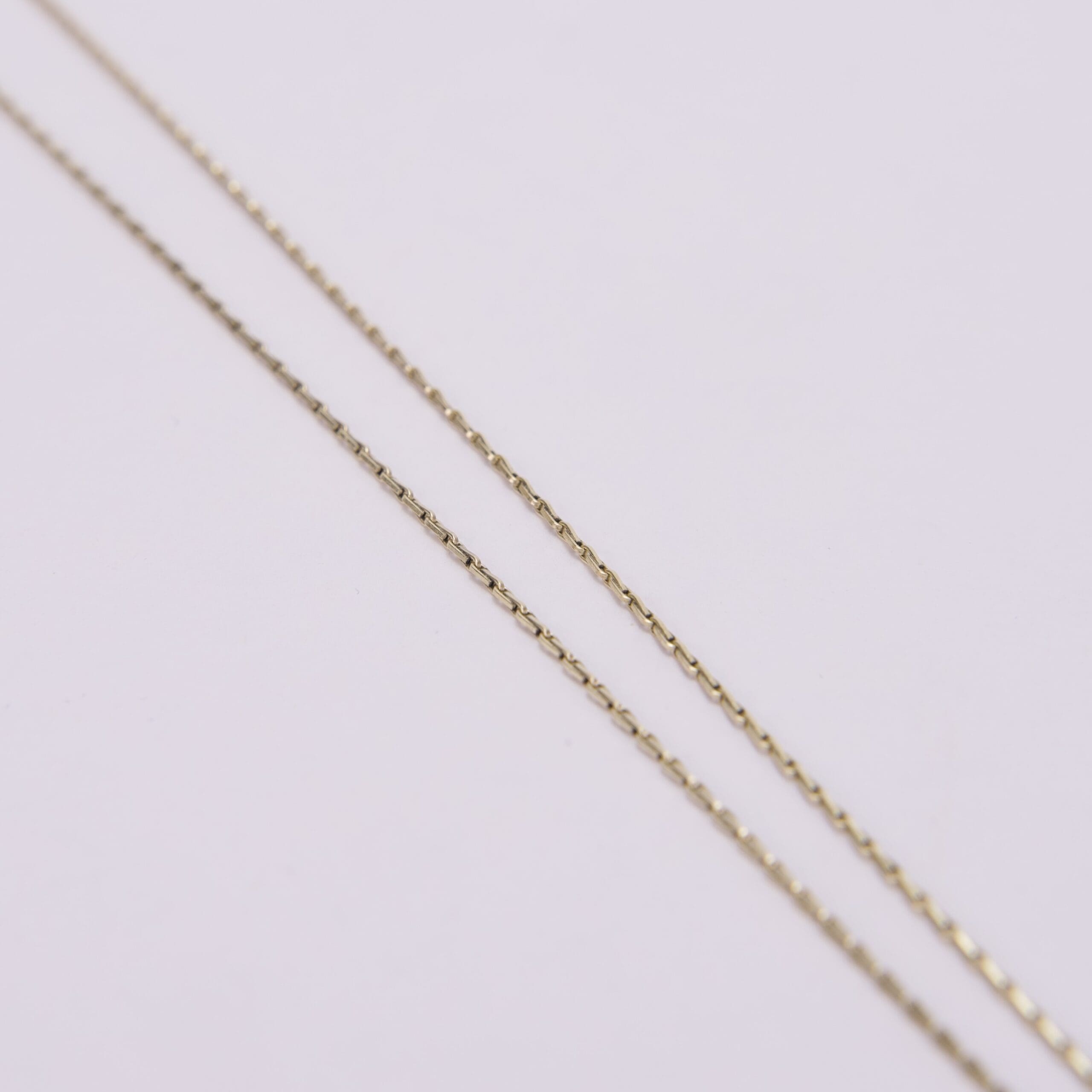 Gold chains on a light background.