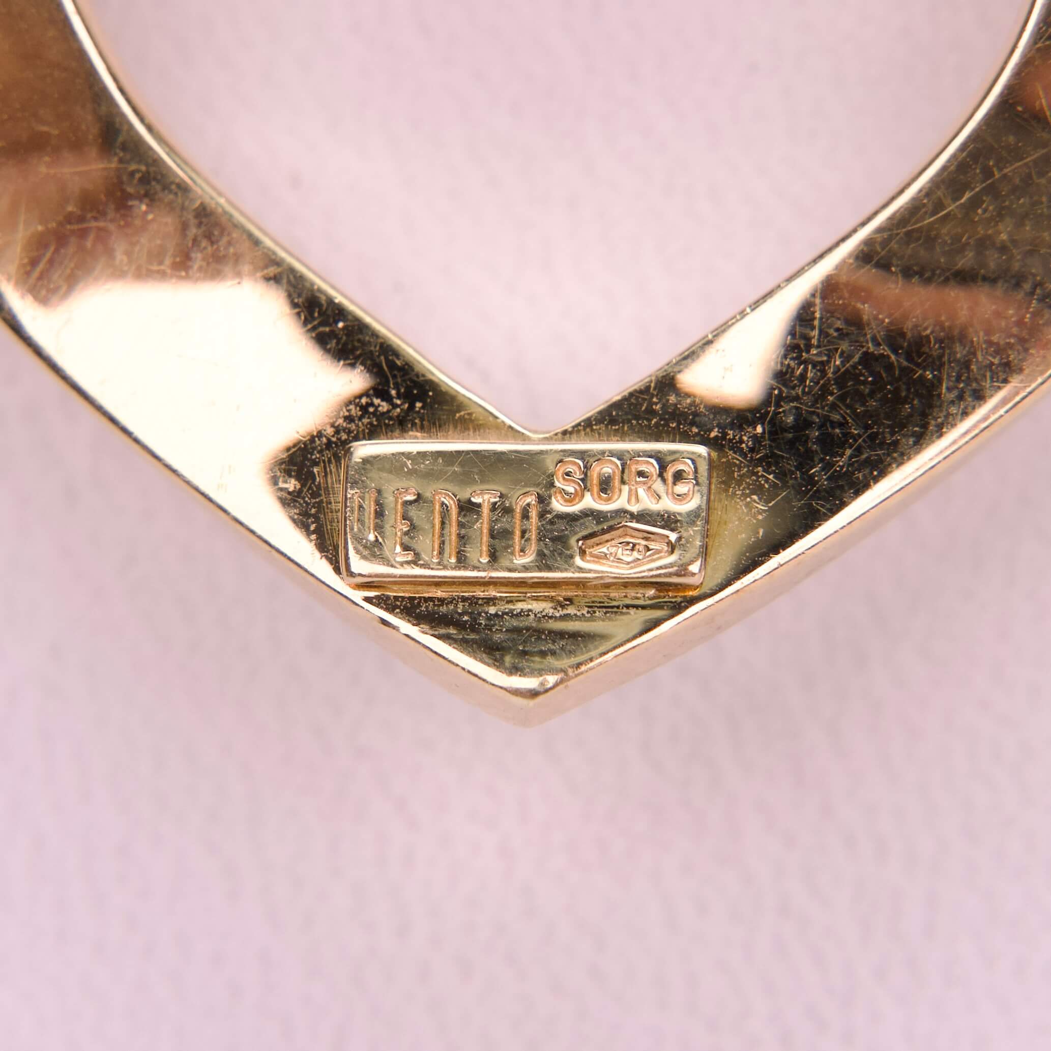 Gold heart-shaped pendant with engraved text.