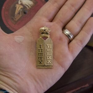 Hand holding small decorative Ten Commandments tablet.