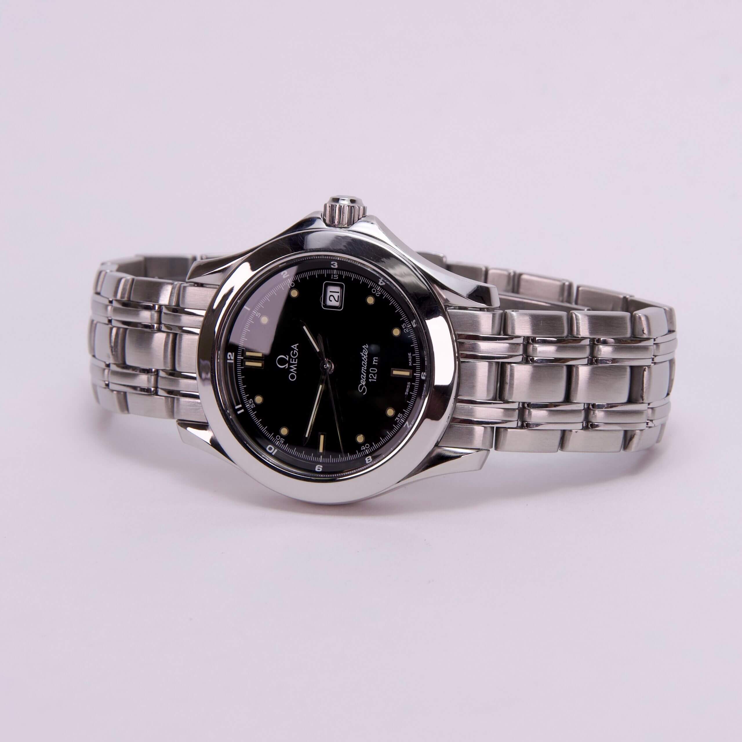 Silver wristwatch with black dial on display.