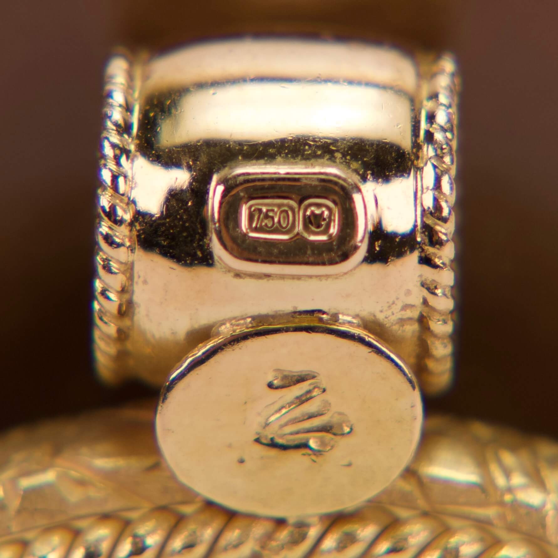 Gold ring with engraved hallmark details.