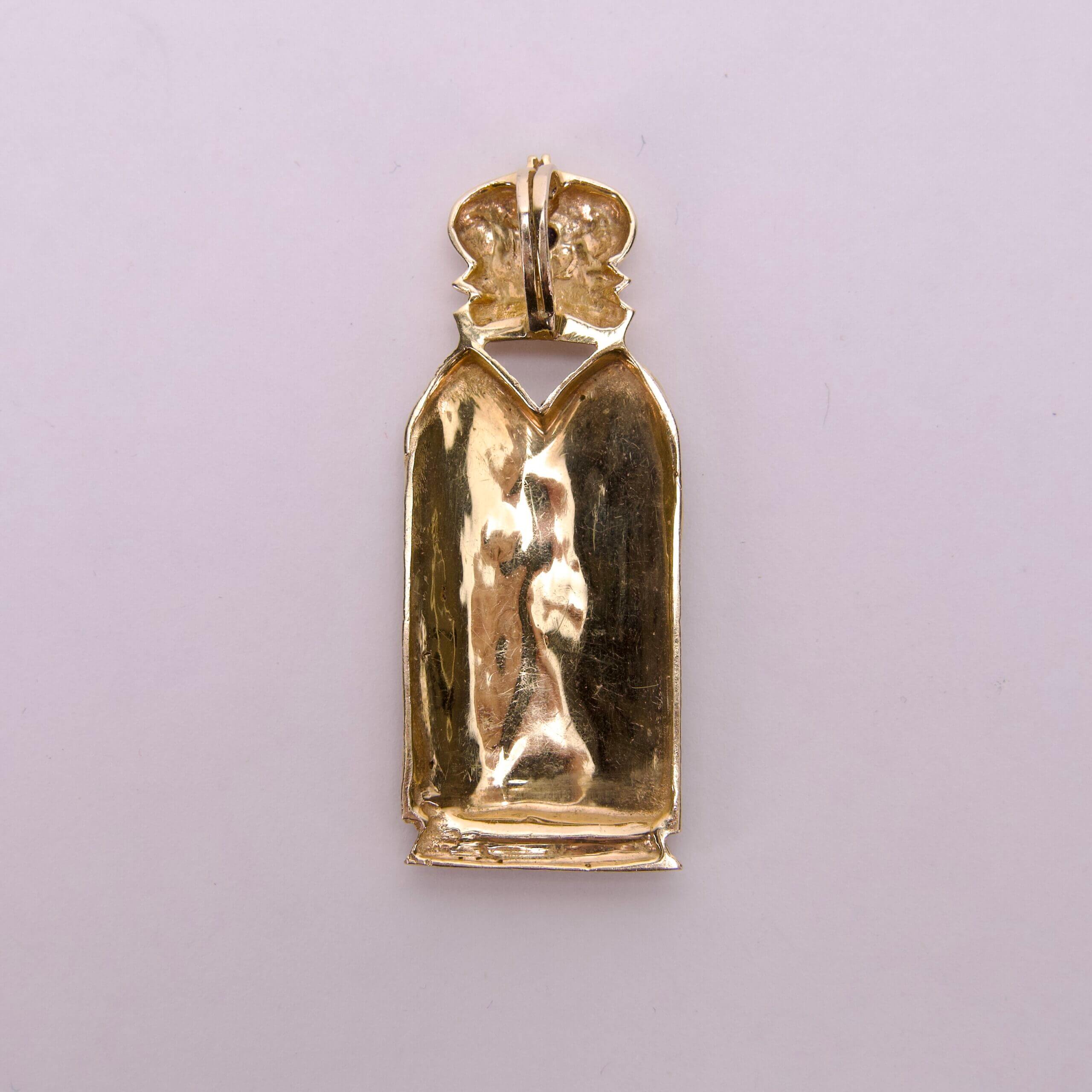 Gold pendant with crown design, back view.