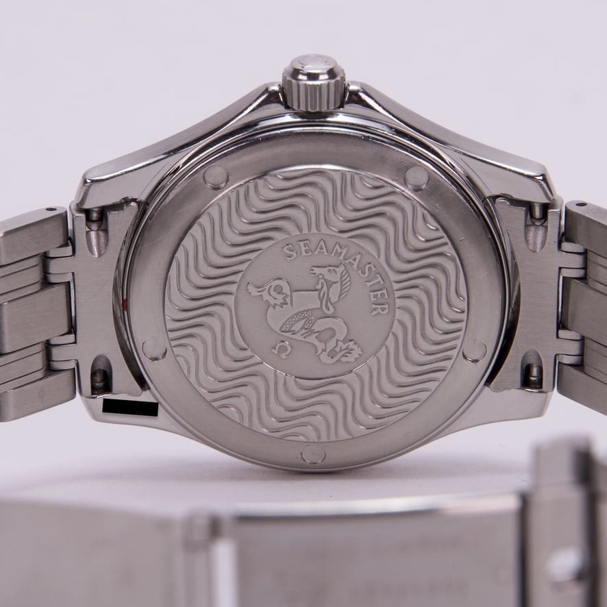 Back of a silver wristwatch with engraving.