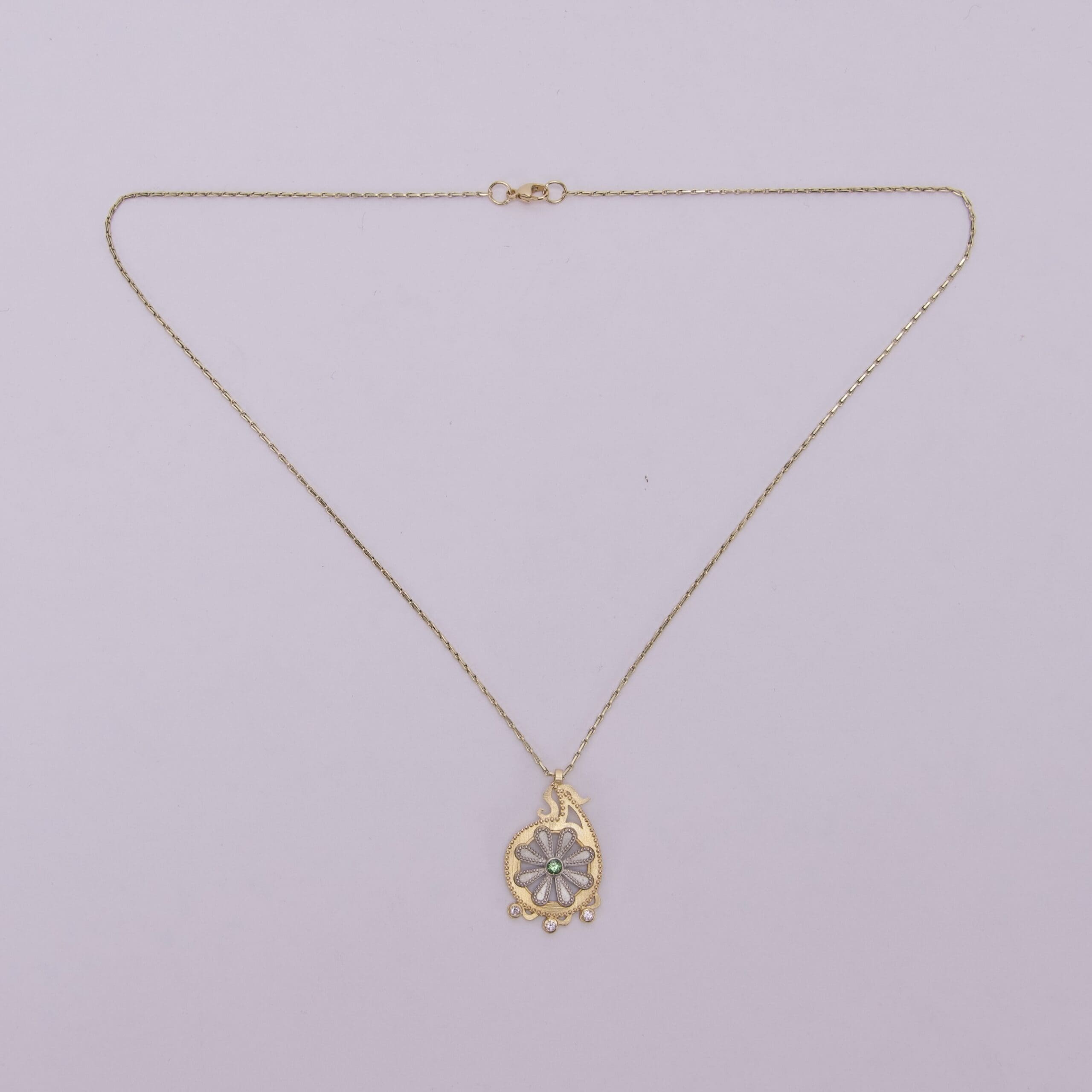 Gold necklace with decorative pendant.