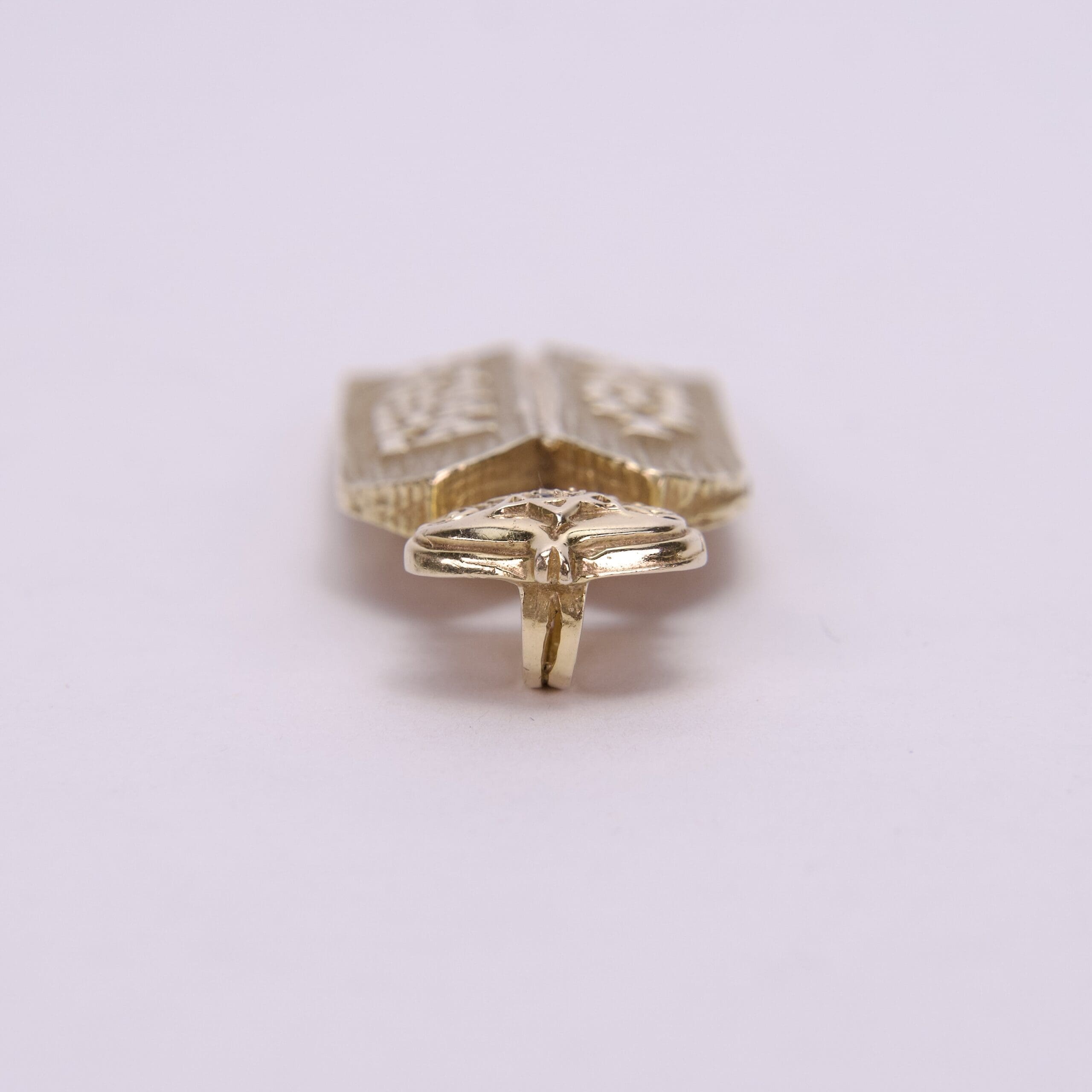 Gold-colored ring with intricate design details.