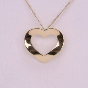 Gold heart-shaped pendant on chain necklace.