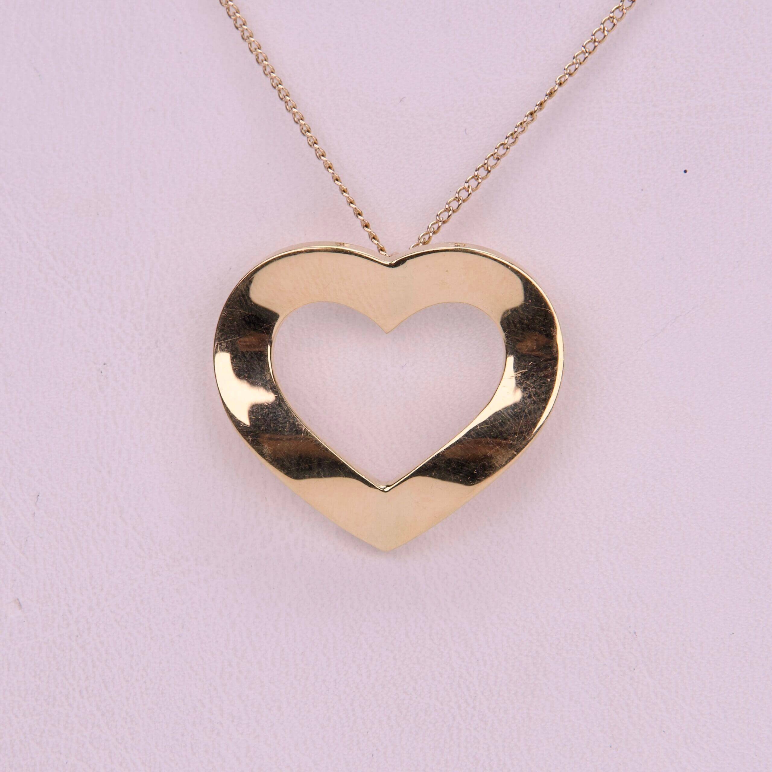 Gold heart-shaped pendant on chain necklace.