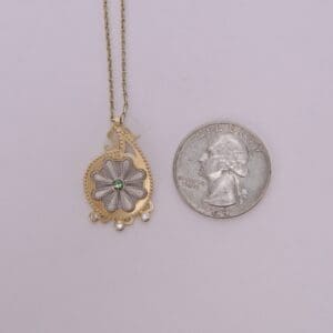 Necklace pendant beside a US quarter coin.