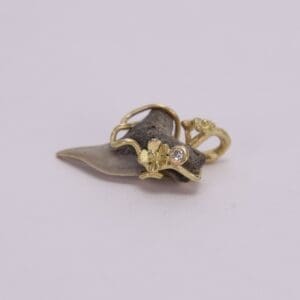 Gold-accented shark tooth pendant with diamond.