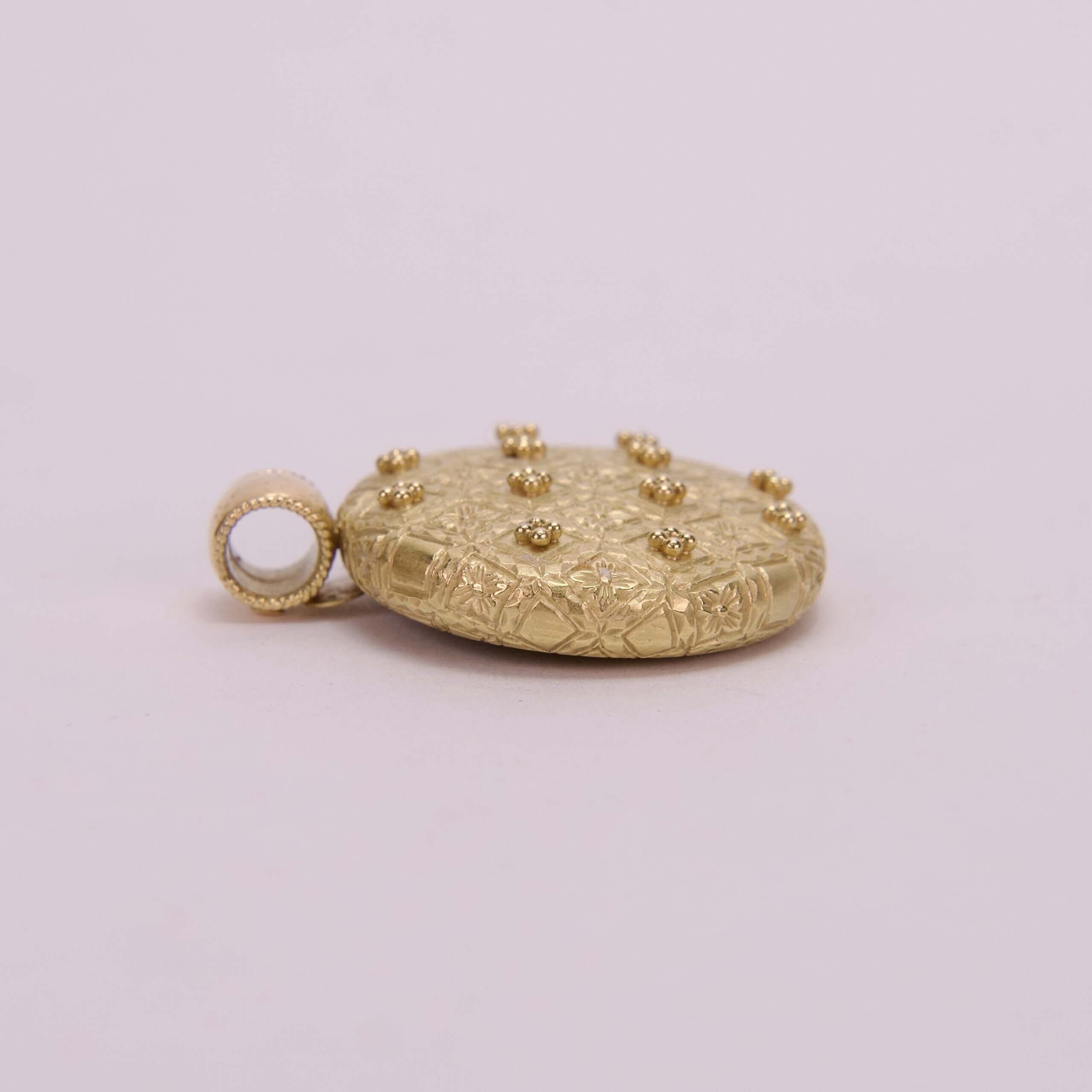 Gold textured pendant with loop attachment.