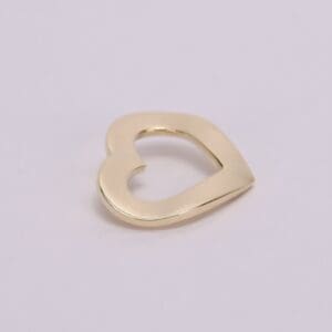 Gold heart-shaped pendant on light background.