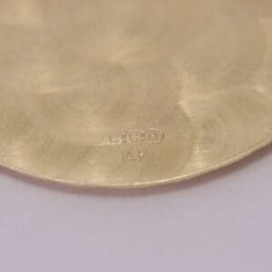 Close-up of gold surface with markings.
