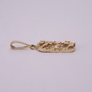 Gold nugget pendant on a plain background.