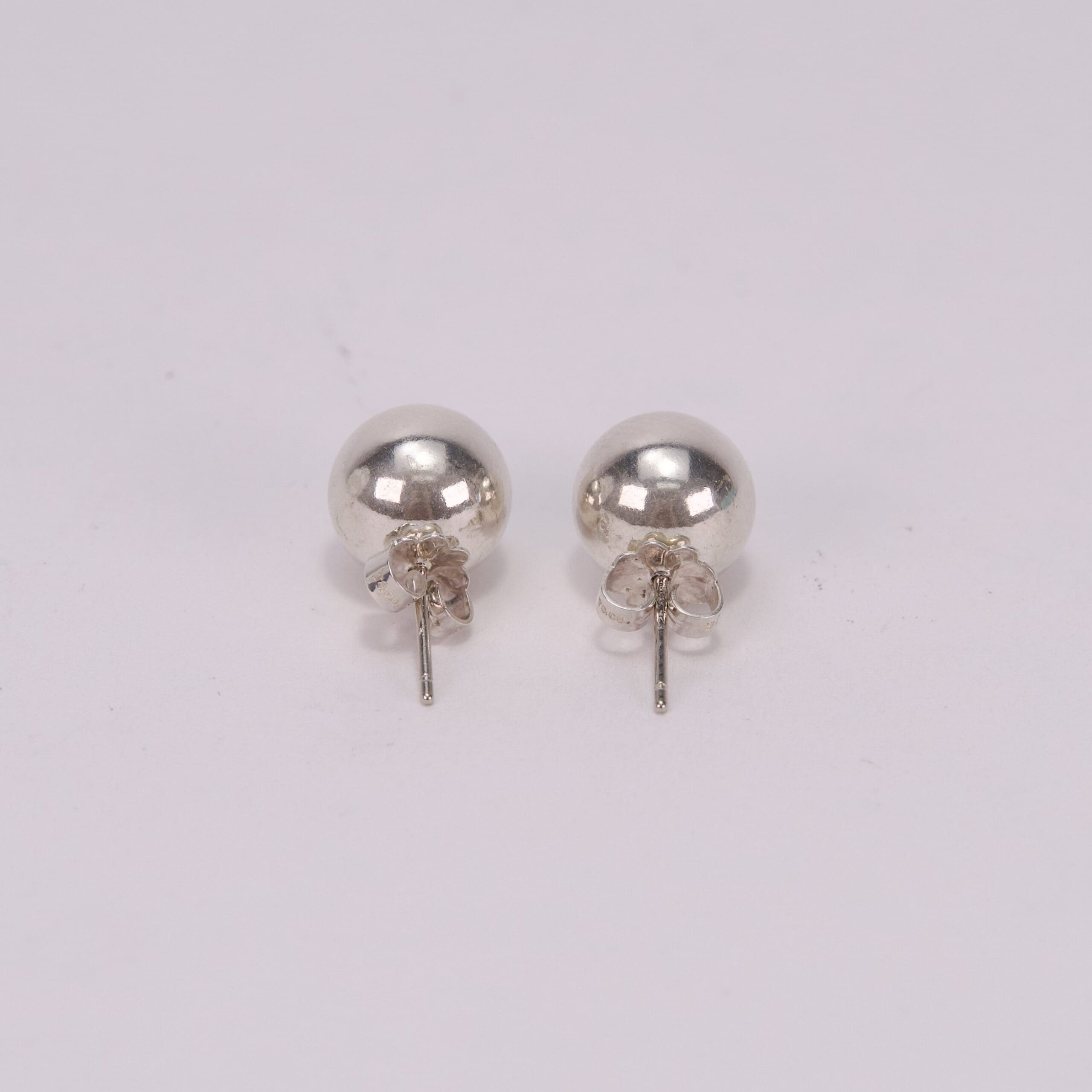 Silver stud earrings on white background.