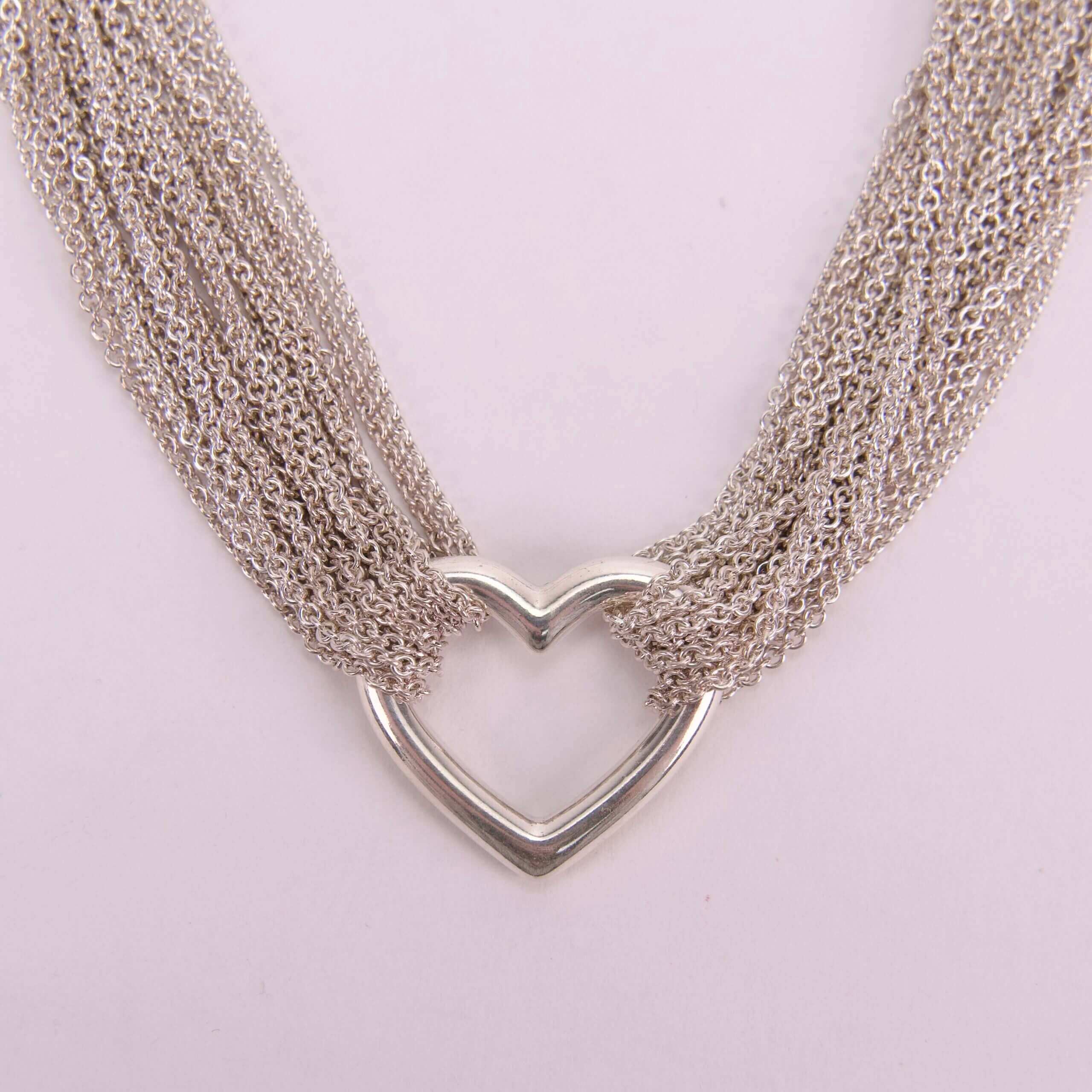 Heart-shaped silver necklace with multiple chains.