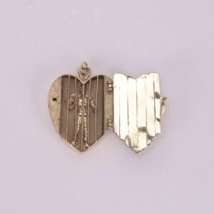 Heart-shaped locket with small figure inside.