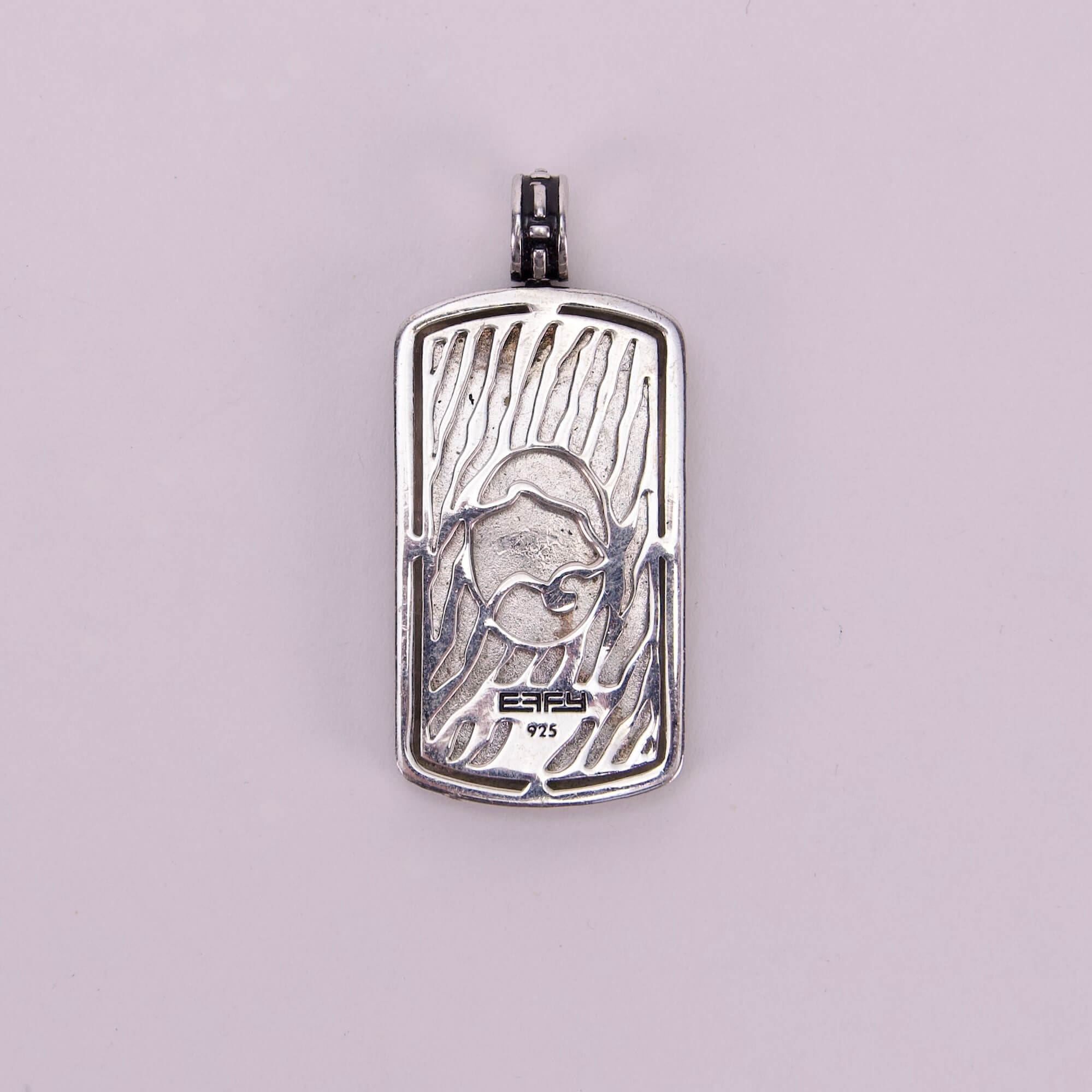 Silver pendant with abstract engraved design.
