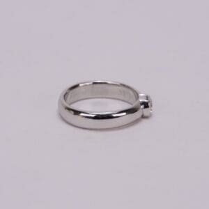 Silver ring with single round gemstone.