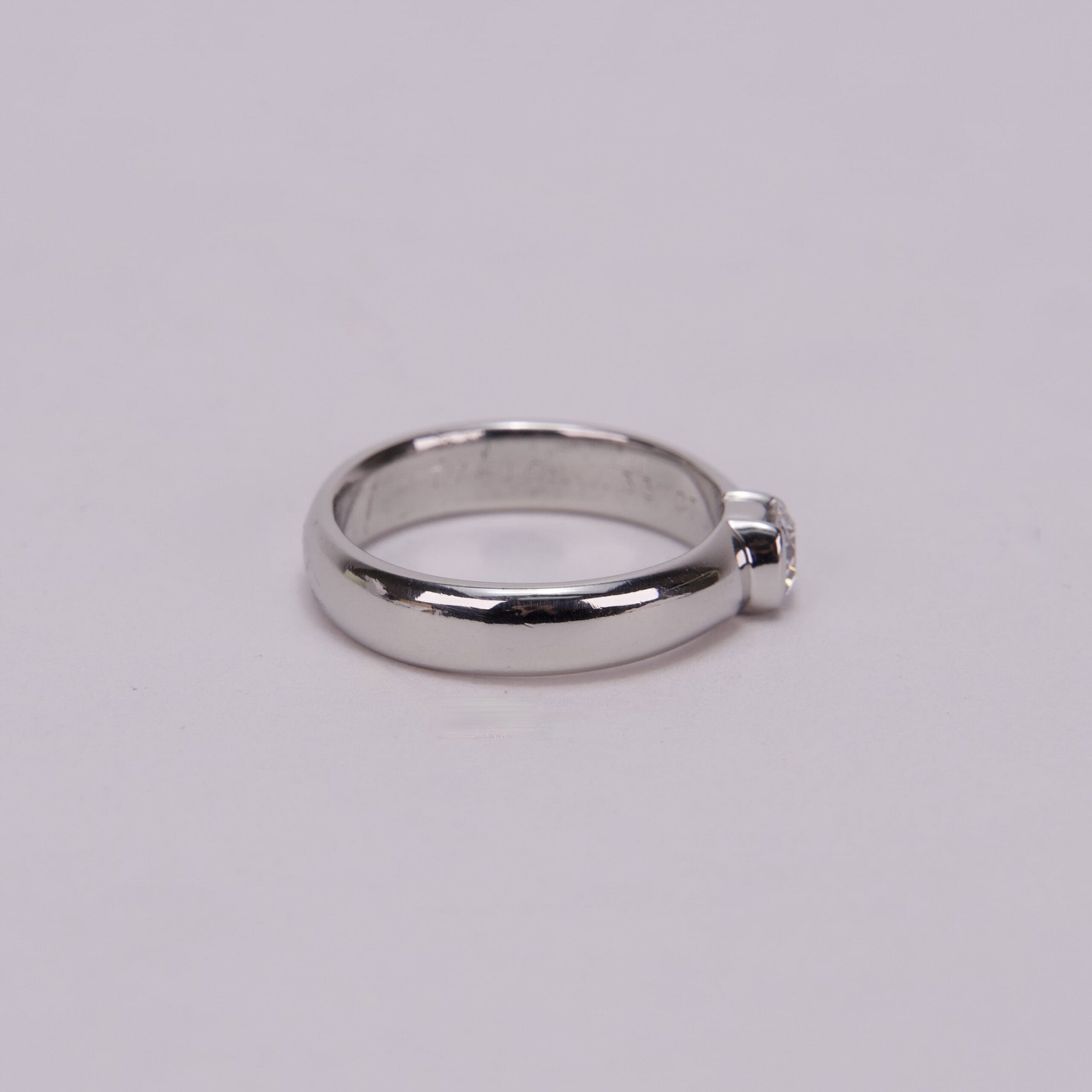 Silver ring with single round gemstone.
